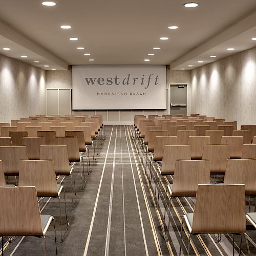 A conference room with rows of chairs facing a screen that reads 