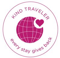 Logo with text "KIND TRAVELER" and "every stay gives back," featuring a circle with a heart.